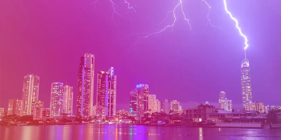 Descarga elétrica atmosférica sendo dissipada por um sistema de proteção instalado no topo do edifício.