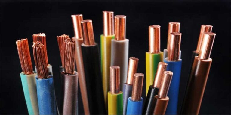 Diversas pontas de fios e cabos elétricos de diferentes cores (azul, verde, marrom, cinza, preto) agrupados verticalmente contra um fundo preto