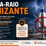 Para-Raio Ionizante instalado em topo de prédio com símbolo de proibição, indicando que não é reconhecido pela NBR 5419 e pode gerar riscos à segurança.